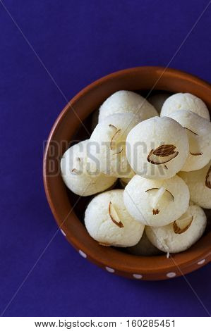 Indian Sweet or Dessert - Rasgulla, Famous Bengali sweet in clay bowl on blue background