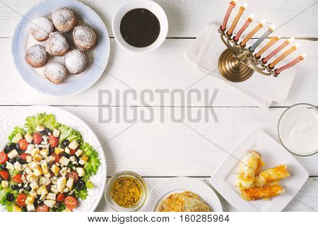 Traditional Hanukkah dishes on the white wooden table