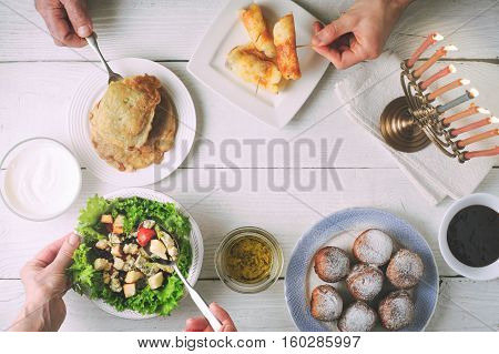 Hanukkah dinner with traditional dishes on the white wooden table