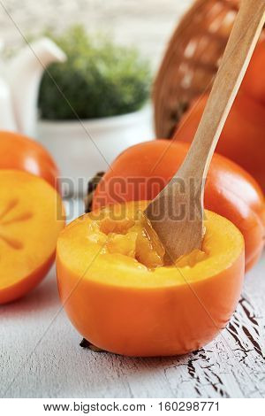 Japanese persimmon (Diospyros kaki) on white rustic wooden background