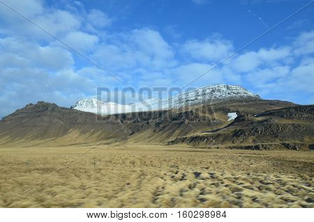 Clouds and blue skies above the Rhyolite Mountains in Iceland.