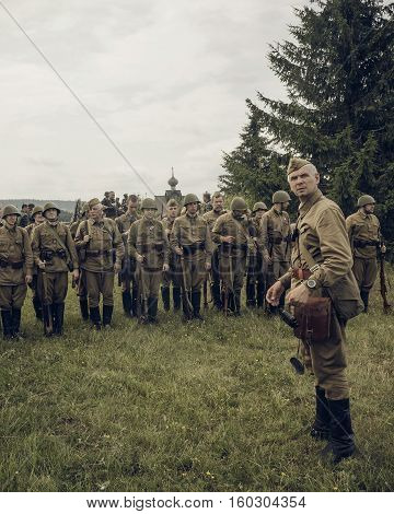 PERM RUSSIA - JULY 30 2016: Historical reenactment of World War II summer 1942. Soviet officer in front of the line of soldiers