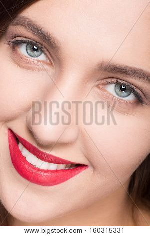 Face of model woman with clean skin looking at camera. Lady with white face toothy smiling for camera in studio.