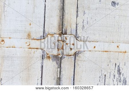 Old door from darkened boards with archaic iron plates