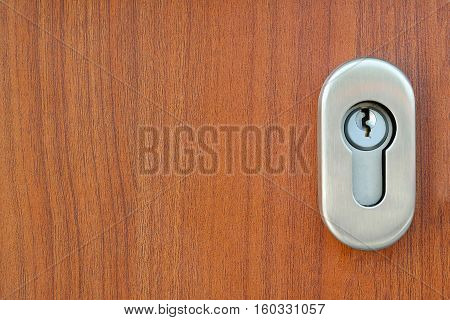 Stainless steel door lock and a Keyhole on the wooden door