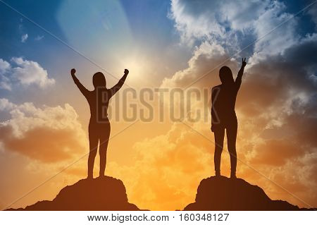 Silhouette Of Winning Success Woman At Sunset Or Sunrise Standing And Raising Up Her Hand In Celebra