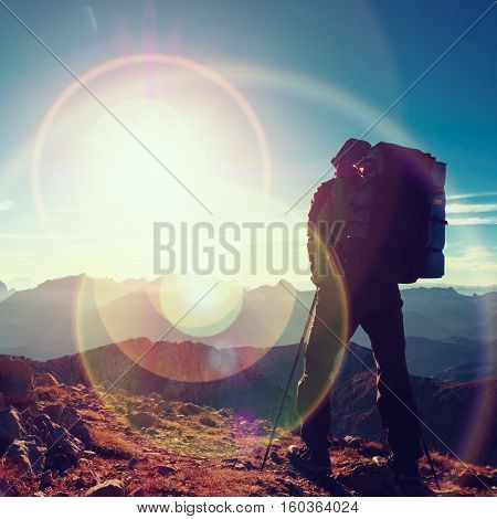 Lens Flare Defect.  Tourist Guide On Trekking Path  With Poles And Backpack.  Experienced Hiker