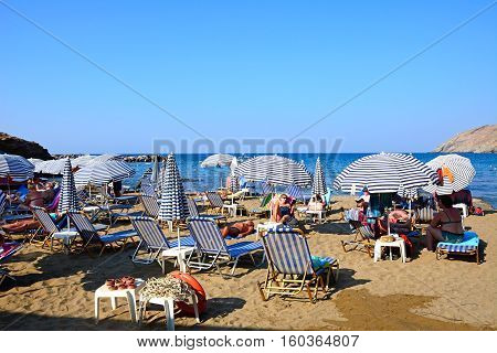 PANORMOS, CRETE - SEPTEMBER 15, 2016 - Tourists relaxing on the sandy beach with views towards the Aegean sea Panormos Crete Greece Europe, September 15, 2016.