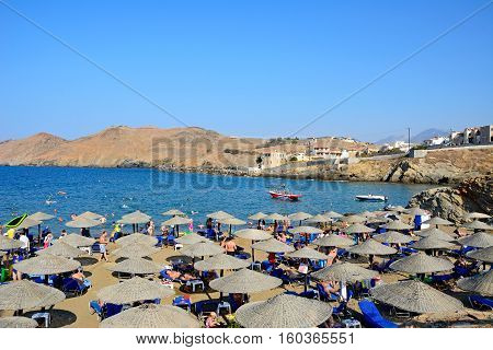 PANORMOS, CRETE - SEPTEMBER 15, 2016 - Tourists relaxing on the sandy beach with views towards the Aegean sea and rocky coastline Panormos Crete Greece Europe, September 15, 2016.