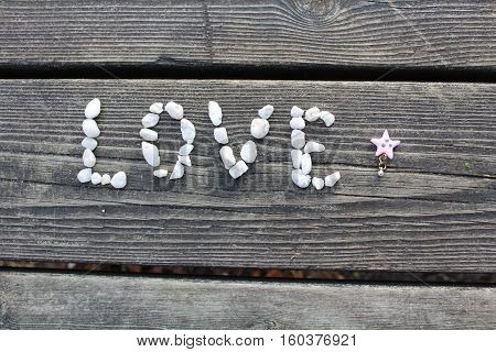 writing lova with stones on the wood