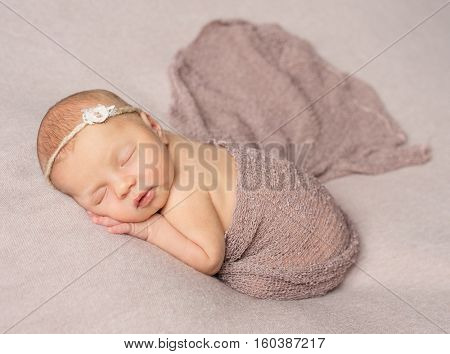 bare sweet sleeping newborn girl covered with knitted shawl