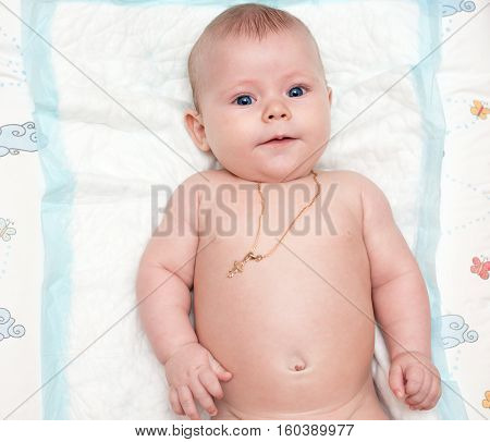 little baby with blue eyes lies and look at the camera