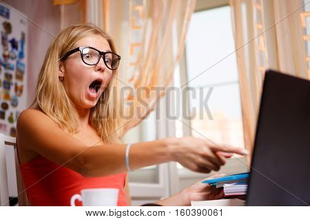 Blonde woman is outraged by what she saw on screen and pointing finger on it