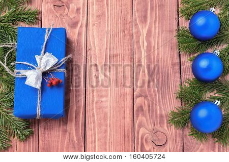 Christmas New Year composition with tangerines, cones, nuts, wicker basket and fir branches in rustic style on old wooden background, selective focus, Background new year, fir, gift, cones, orange, blue ball, red background