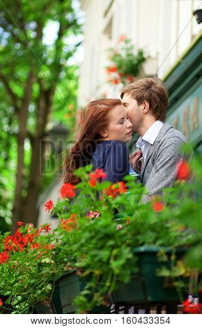 Man And Woman Together On Balconyof Their House Or Hotel With Blossoming Geranium