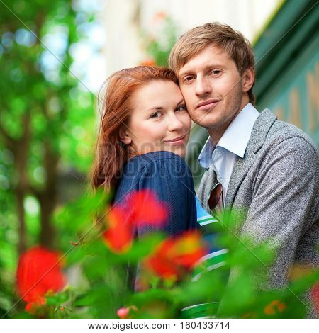 Man And Woman Together On Balcony With Blossoming Geranium
