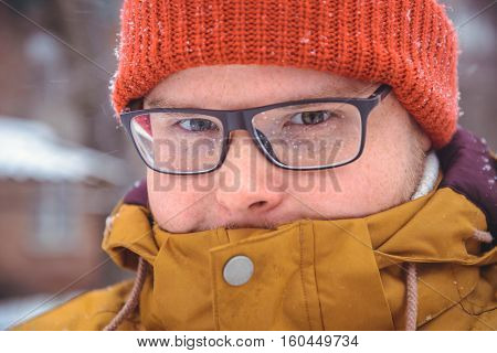 Adult man wearing glasses. The man smiles. Winter, snow