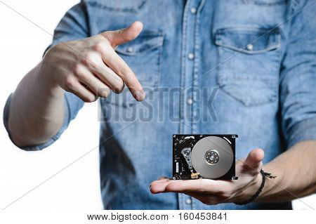 Casual man in denim shirt showing digital tablet computer screen in hands. Isolated on white. Clipping path for display included. He points a finger at the display.