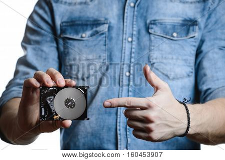 Casual man in denim shirt showing digital tablet computer screen in hands. Isolated on white. Clipping path for display included. He points a finger at the display.