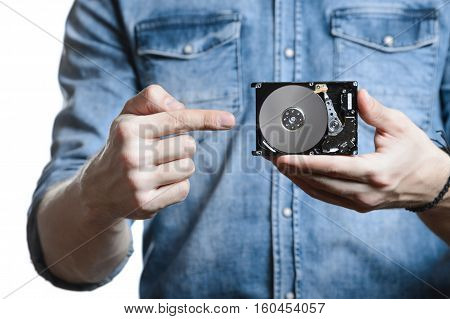 Casual man in denim shirt showing digital tablet computer screen in hands. Isolated on white. Clipping path for display included. He points a finger at the display.