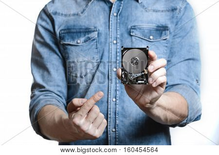 Man's hand holds a 2.5 inch hard drive. He's points to the hard disk. View of the backside HDD, from the PCB. Isolated on white background.