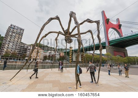 Bilbao Spain - October 16: Group of tourist visiting Louise Bourgeois giant 11 meter high spider at the back of the Guggenheim museum on October 16 2016 in Bilbao Spain.