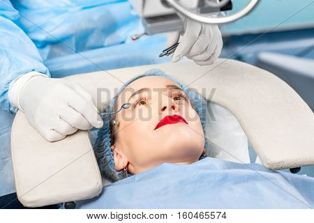 Operating the eye of female patient with surgical tools