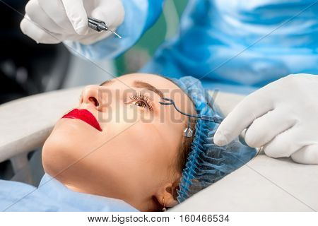 Operating the eye of female patient with surgical tools
