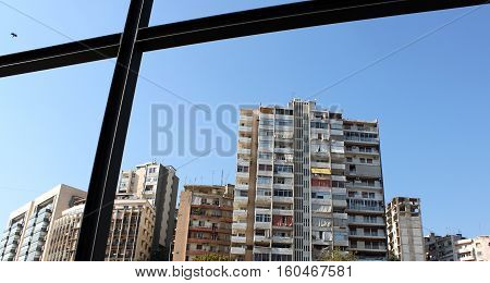 An old building in Lebanon with a bird flying into the frame of metal.