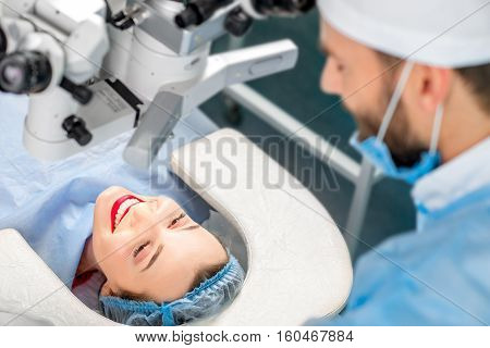 Happy patient speaking with surgeon lying on the couch before the operation in the operating room