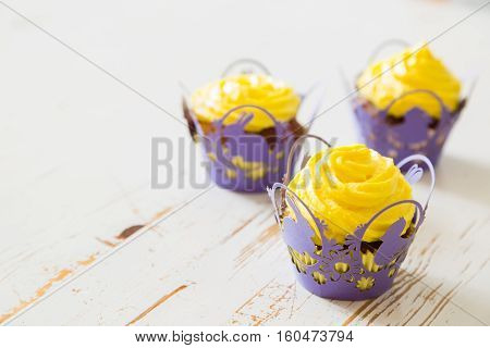 Easter cupcakes with eggs and flaffy willow, wood background