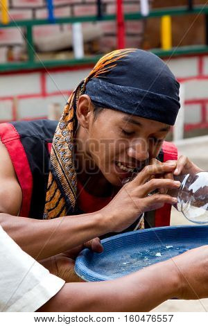 BATAM INDONESIA - DECEMBER 7 2012: Local citizen performing act (eating glass) in traditional attire