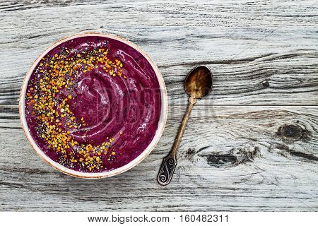 Acai breakfast superfoods smoothies bowl with chia seeds bee pollen toppings. Immune boosting anti inflammatory smoothie with turmeric honey and maca powder. Overhead top view flat lay copy space
