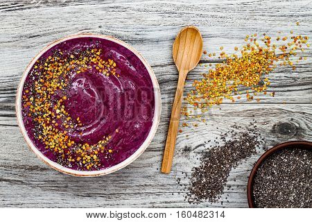 Acai breakfast superfoods smoothies bowl with chia seeds bee pollen toppings. Immune boosting anti inflammatory smoothie with turmeric honey and maca powder. Overhead top view flat lay copy space