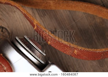 Fragment of an old film camera with its casing on a wooden plank.