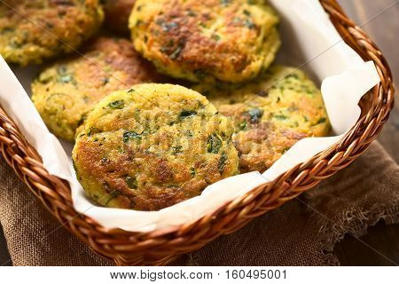 Zucchini couscous and parsley fritters in basket photographed with natural light (Selective Focus Focus in the middle of the first fritter)