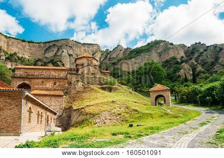 Mtskheta, Georgia. The Picturesque View Of Shiomgvime Or Shio-Mgvime Monastery, Medieval Monastic Complex In Limestone Canyon In Sunny Summer Spring Day Under Cloudy Sky.