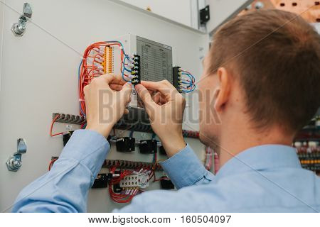 Electrician near the low voltage cabinet. Uninterrupted power supply. Electricity.