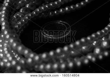 Wedding rings on the table with necklace on background