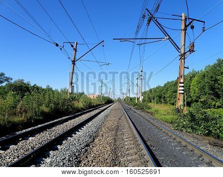 Double-track electrified railway on a clear sunny day.