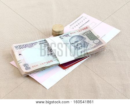 Concept of different modes of payment indicated through Indian rupees and coins, credit and debit cards and check.