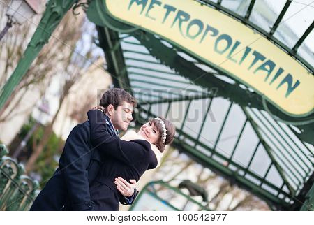 Couple Kissing Under The Metro Sign In Paris