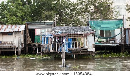 The old hut, shacks houses stand on stilts in the water on the waterfront. Houses of poor people. Thailand Bangkok