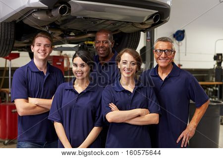Portrait Of Auto Mechanics Working In Garage