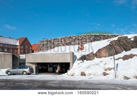 HELSINKI, FINLAND - MARCH 13, 2010: People near the enter of Temppeliaukio Church (Church of the Rock) on Lutherinkatu. Was built directly into solid rock and opened in 1969.