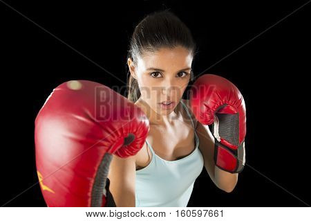 young attractive latin fitness woman with girl red boxing gloves posing in defiant and competitive fight attitude in female boxer and fighter concept isolated on black background