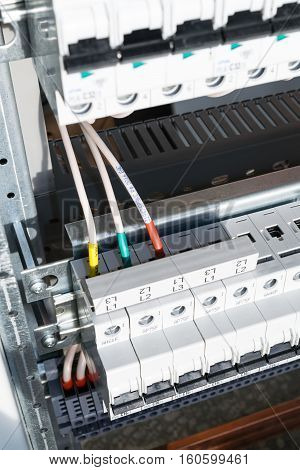 Connecting cables with cable lugs to circuit breakers in the electrical control panel on the artboard. Alignment of the components to ensure safety and reliability.