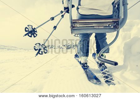 Back view of skier riding a lift. Skking in the mountains.