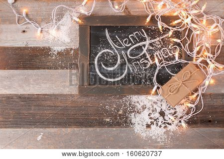 Christmas decoration and gift box with space for greeting Merry Christmas on chalk blackboard.