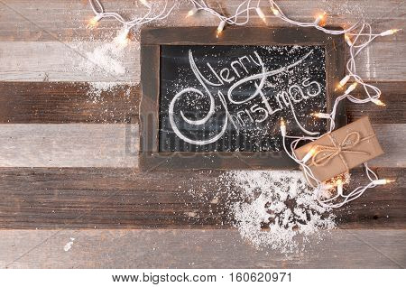 Christmas decoration and gift box with space for greeting Merry Christmas on chalk blackboard.